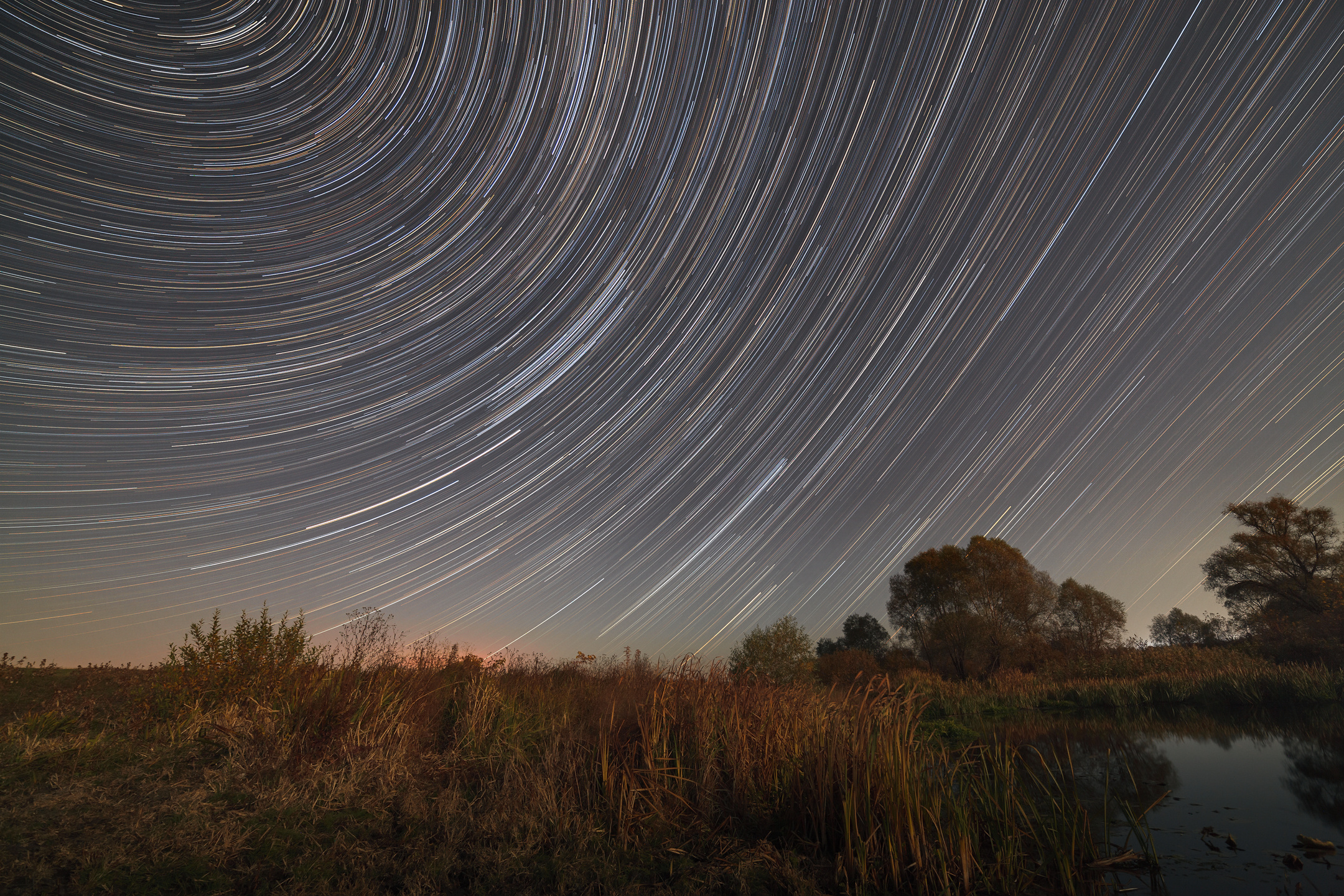 Star trails in the night sky. A view of the starry space in the background of the river.